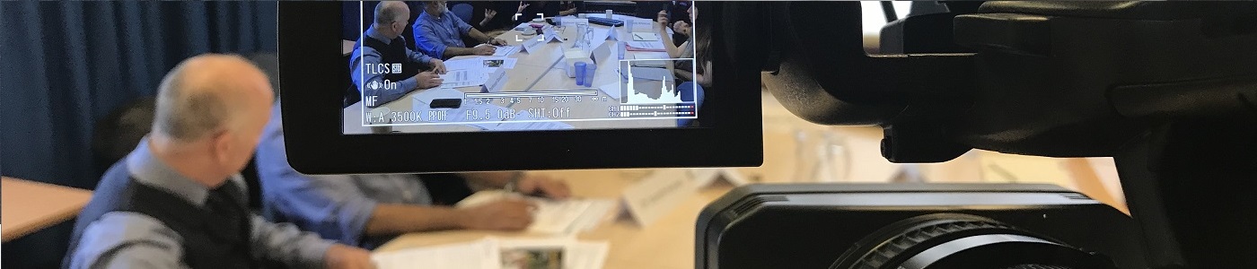 View from behind a camera filming a meeting